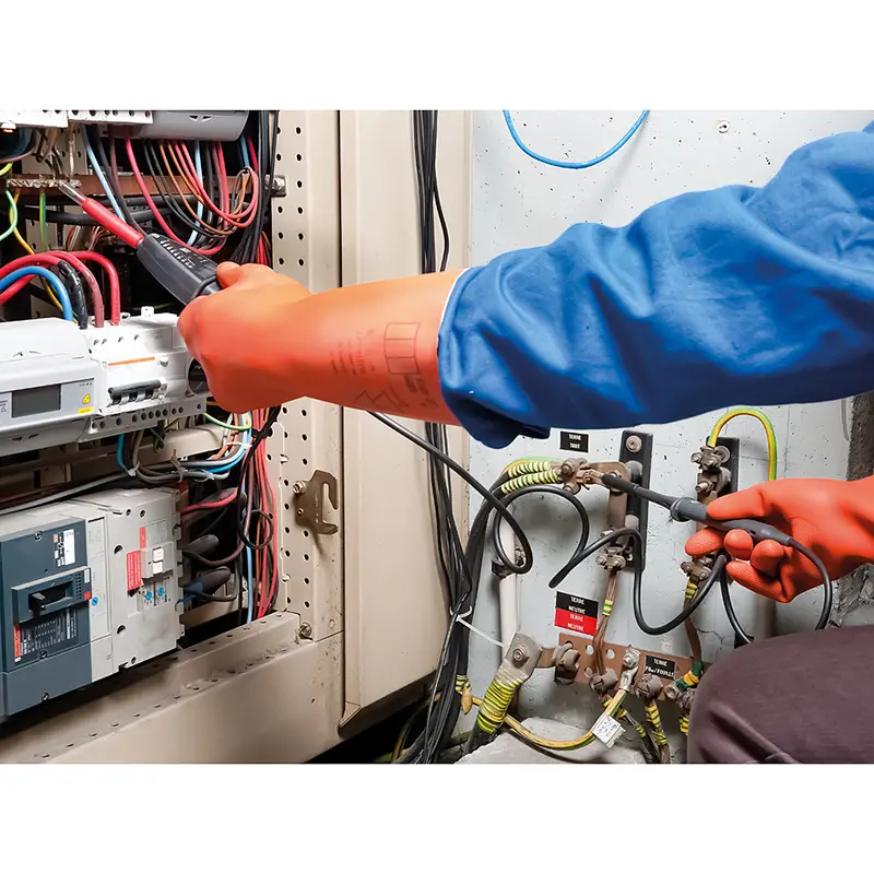Spannungsprüfer CA 773 wird von Elektriker mit Schutzhandschuhen an Schaltschrank verwendet
